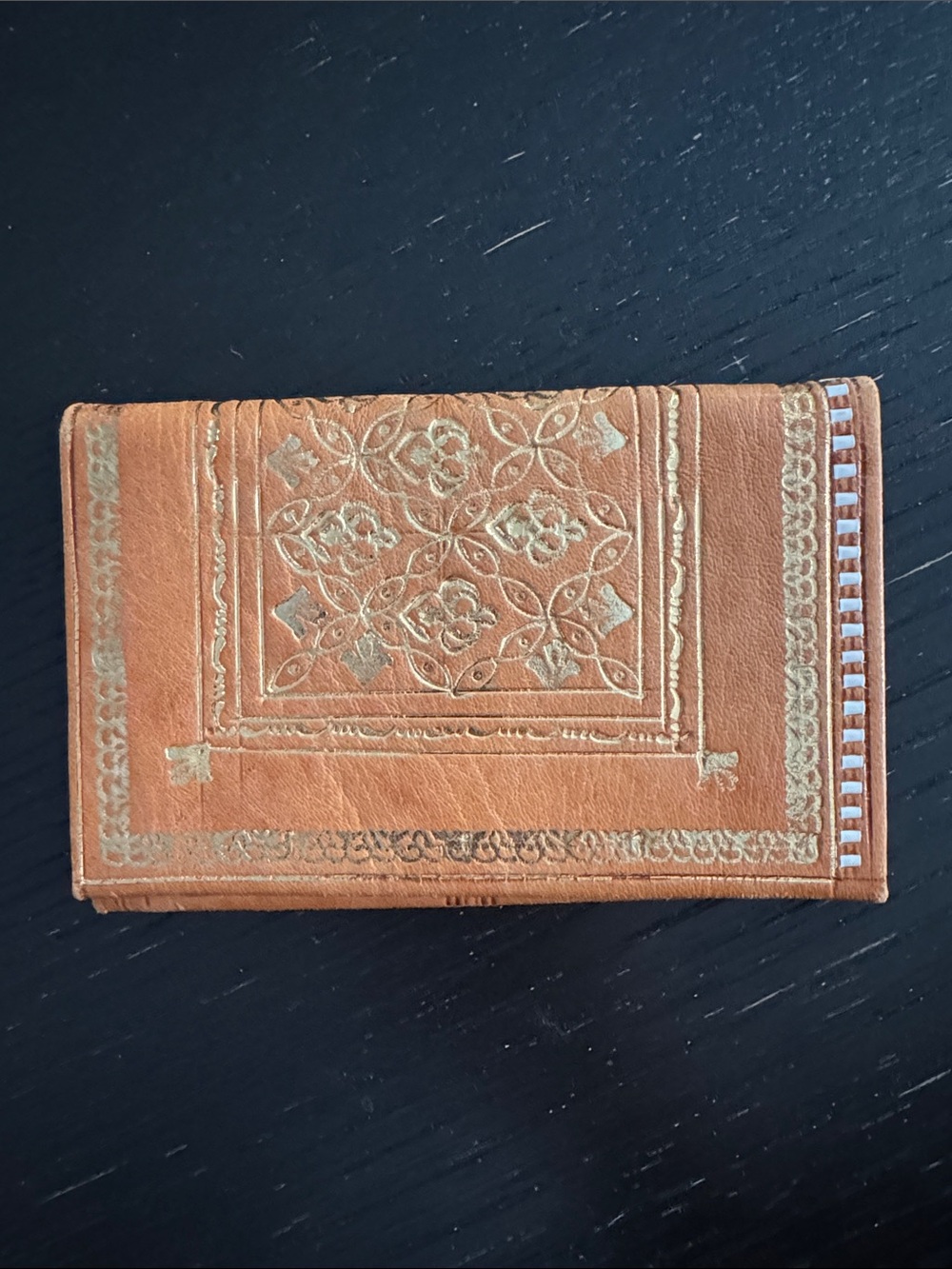 Tan leather bifold wallet. 23K gold floral accent.